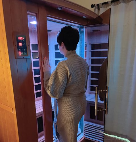 woman stepping into sauna